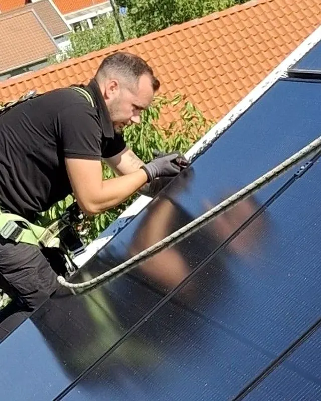 Mathias på ett tak med fallskydd, i arbete vid solcellerna